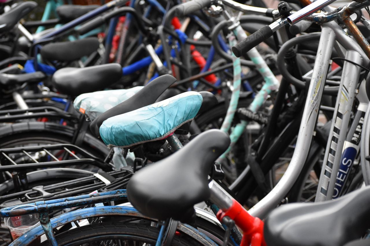 about-us-01 Vibrant collection of bicycles with colorful seats captured in an Amsterdam street.